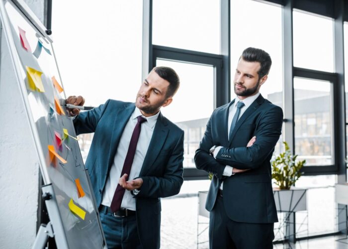 handsome businessmen looking at white board in modern office